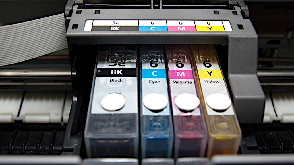 Printer inkjet memproyeksikan tetesan kecil tinta ke atas kertas.
